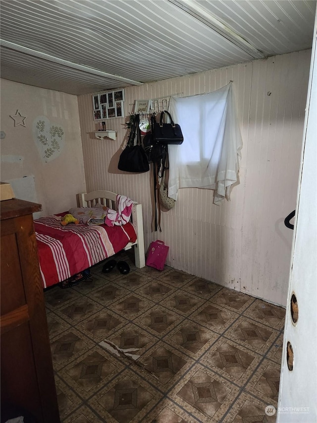 bedroom featuring wood walls