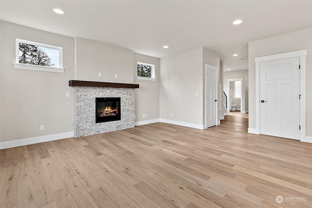 unfurnished living room featuring a fireplace and light wood-type flooring