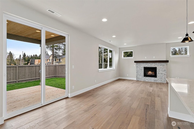 unfurnished living room featuring a fireplace and light hardwood / wood-style floors