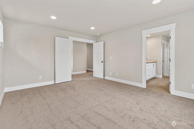 unfurnished bedroom with light carpet and ensuite bathroom