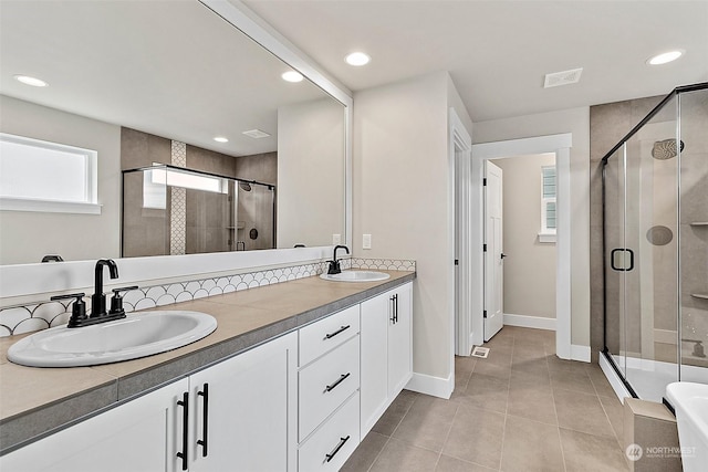 bathroom featuring tile patterned flooring, vanity, and a shower with shower door