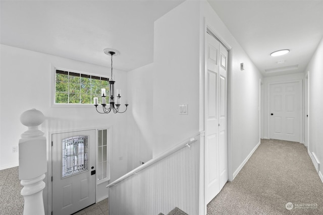 foyer featuring a notable chandelier and carpet