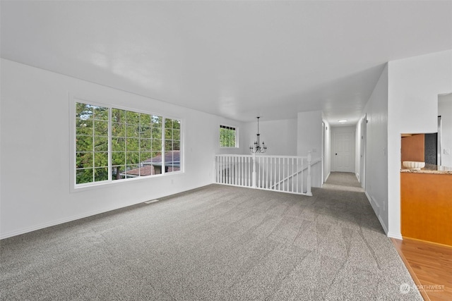 empty room featuring carpet and a chandelier