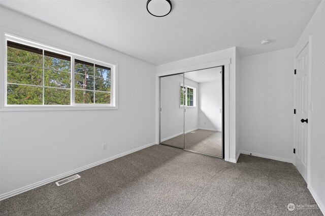 unfurnished bedroom with a closet and carpet flooring