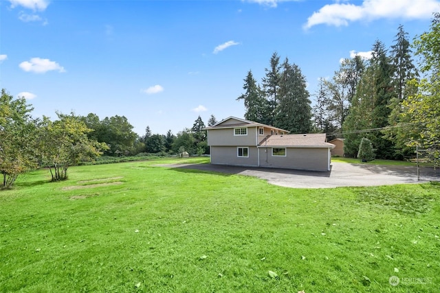 back of house with a lawn and a patio