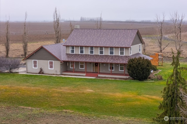 view of front of house with covered porch, a rural view, and a front lawn