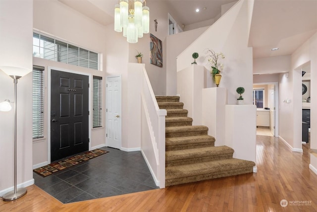 entrance foyer featuring a high ceiling, dark hardwood / wood-style flooring, and a notable chandelier