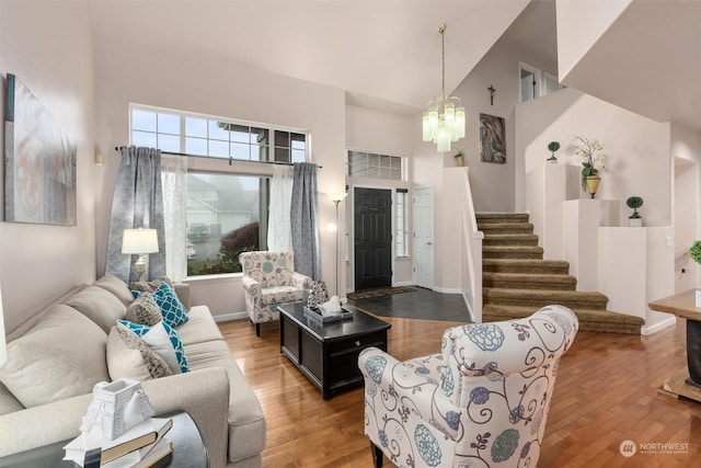 living room featuring a notable chandelier, a high ceiling, and hardwood / wood-style floors