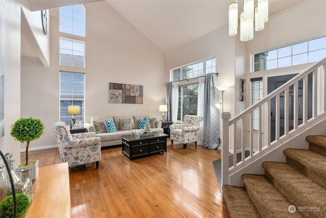 living room with a high ceiling, hardwood / wood-style floors, and an inviting chandelier