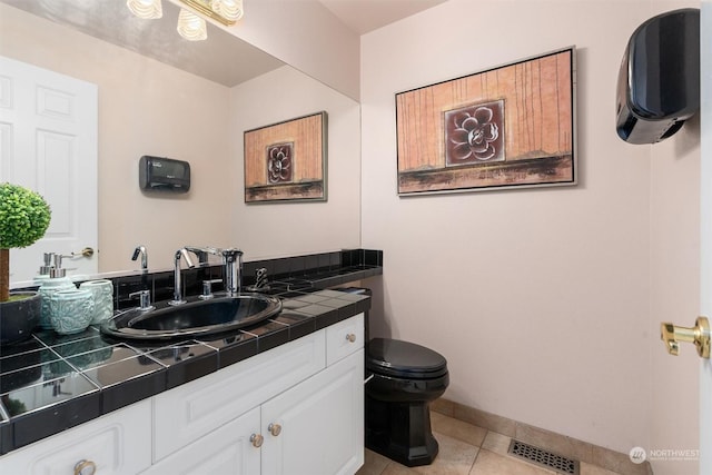 bathroom with toilet, tile patterned floors, and vanity