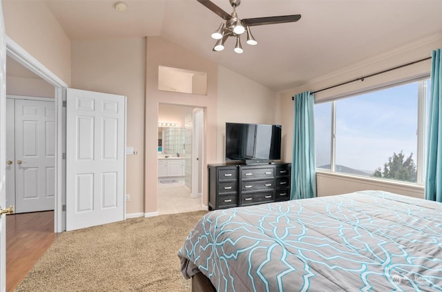 bedroom with ceiling fan, ensuite bath, vaulted ceiling, and light colored carpet