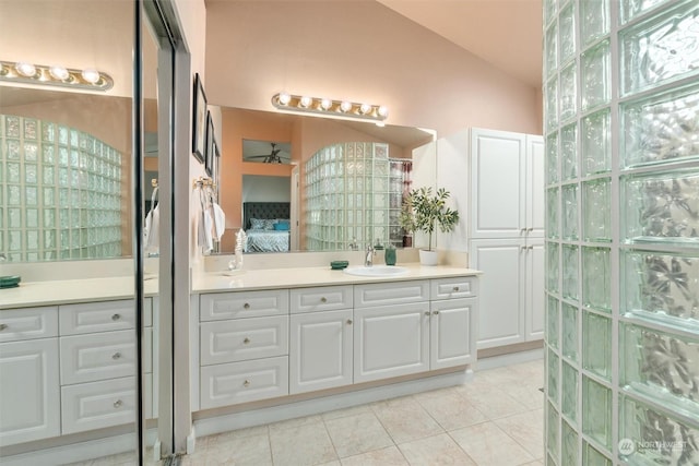 bathroom with vaulted ceiling, tile patterned flooring, and vanity