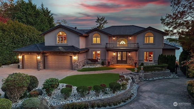 view of front of home with a lawn, a garage, and a balcony