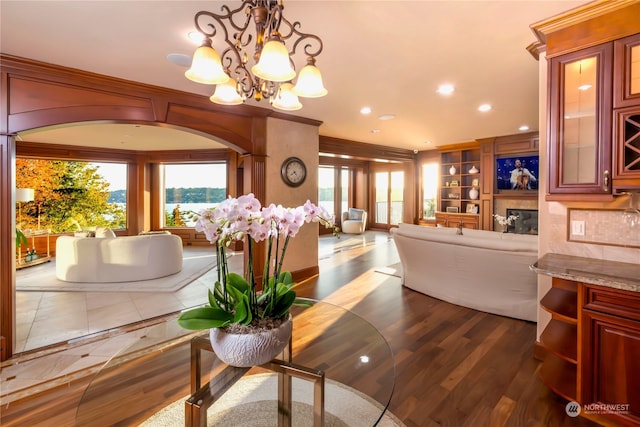 dining area featuring built in shelves, dark hardwood / wood-style floors, and a chandelier