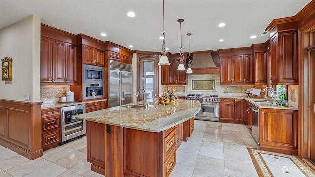 kitchen featuring custom range hood, sink, built in appliances, a center island with sink, and wine cooler