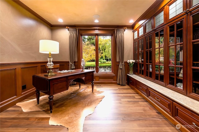 office with light wood-type flooring and ornamental molding