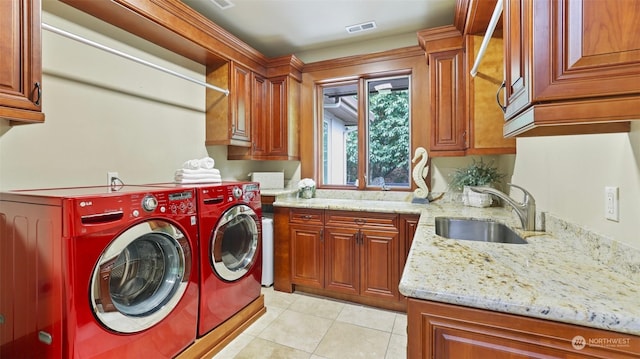 laundry area featuring cabinets, independent washer and dryer, sink, and light tile patterned floors