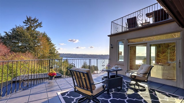 view of patio featuring a balcony and a water view