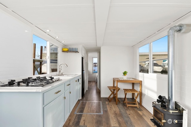 kitchen featuring sink, stainless steel gas cooktop, backsplash, and dark wood-type flooring