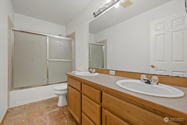 full bathroom with vanity, toilet, and bath / shower combo with glass door