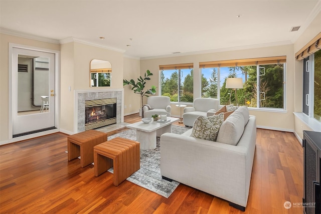 living room featuring hardwood / wood-style flooring, a premium fireplace, and crown molding