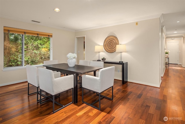 dining room with crown molding and dark wood-type flooring