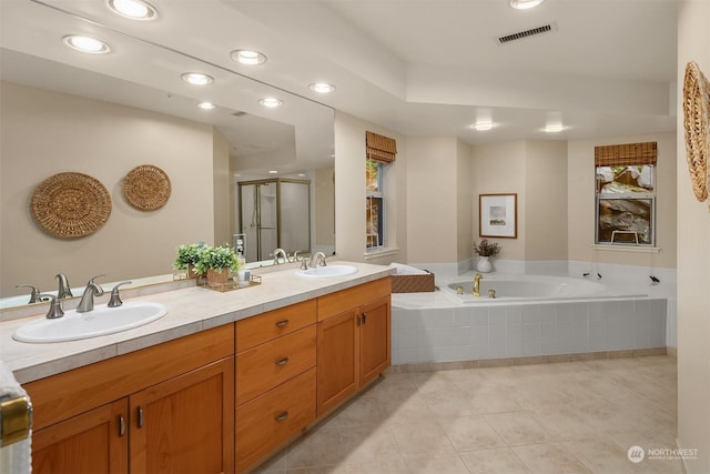 bathroom with plus walk in shower, vanity, and tile patterned floors