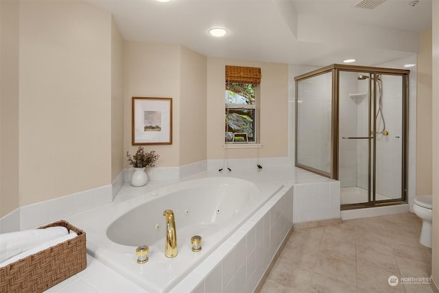 bathroom featuring tile patterned flooring, toilet, and independent shower and bath