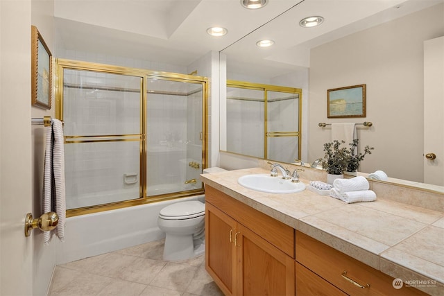 full bathroom with tile patterned floors, vanity, bath / shower combo with glass door, and toilet