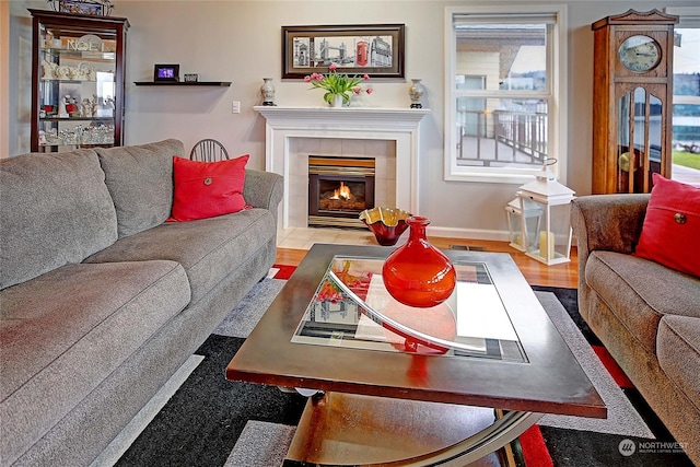 living room featuring a tile fireplace and light wood-type flooring