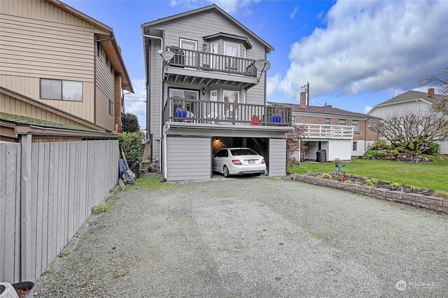 rear view of house featuring a lawn and a balcony