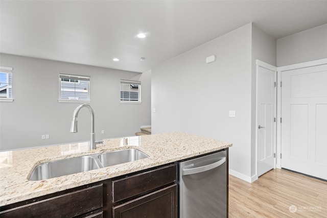 kitchen featuring dishwasher, sink, light stone countertops, dark brown cabinets, and light hardwood / wood-style floors