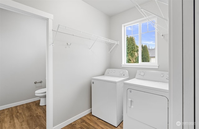 clothes washing area with hardwood / wood-style floors and separate washer and dryer