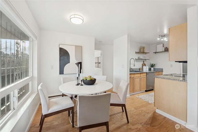 dining space featuring light wood-type flooring and sink