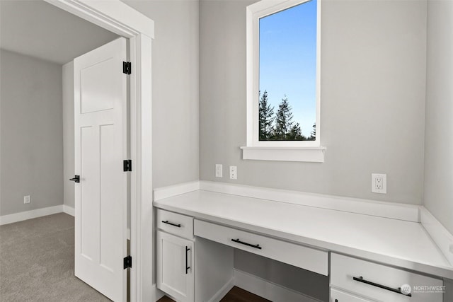 unfurnished office with light colored carpet and built in desk