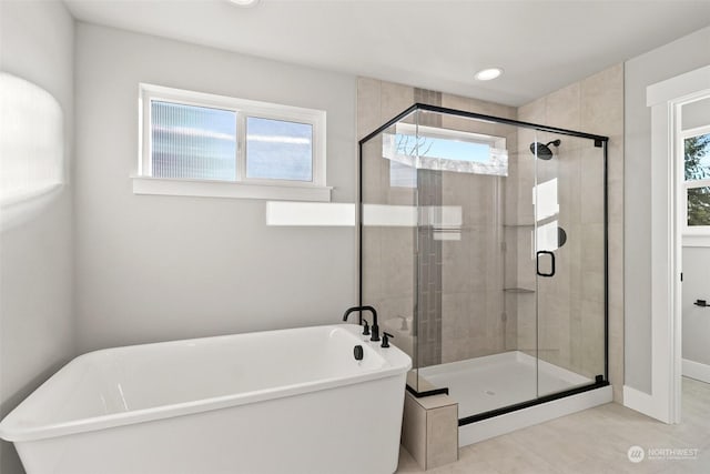 bathroom with independent shower and bath and a healthy amount of sunlight