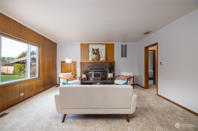 living room featuring a wood stove, wood walls, light colored carpet, and ornamental molding