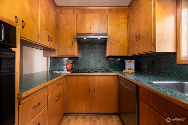 kitchen with decorative backsplash, light hardwood / wood-style flooring, and black appliances