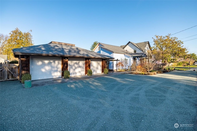 view of front of house with a garage and an outbuilding