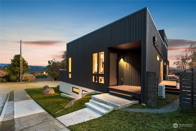 modern home featuring central air condition unit and a yard