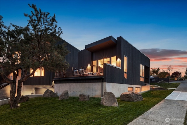 property exterior at dusk featuring a lawn and a balcony