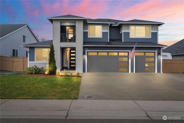 view of front facade with a yard, a garage, and a balcony