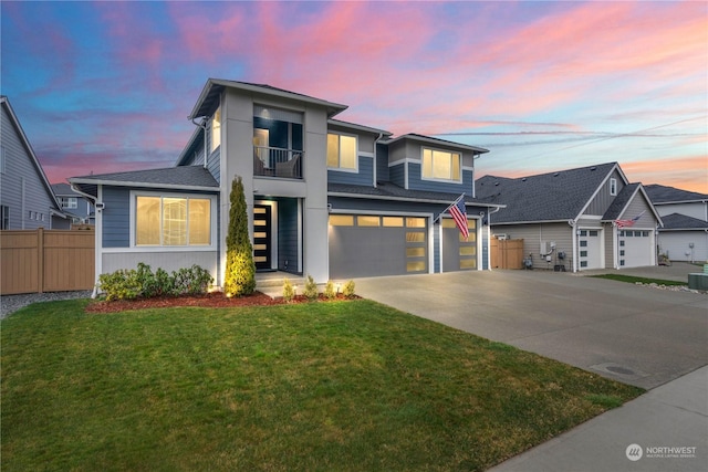 view of front of home featuring a garage, a balcony, central AC unit, and a lawn