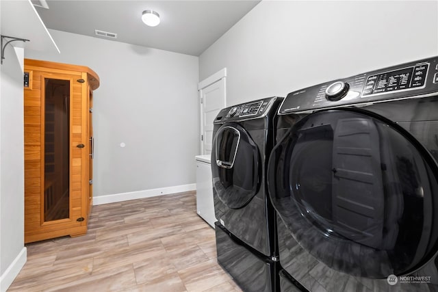 clothes washing area with washing machine and dryer