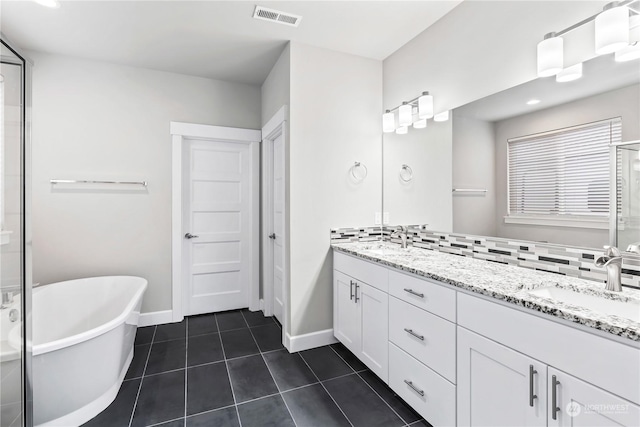 bathroom featuring vanity, a tub to relax in, and tile patterned floors