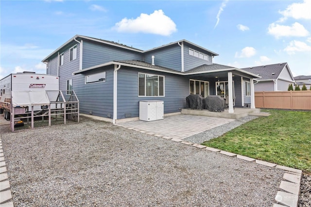 back of property featuring a patio and a lawn