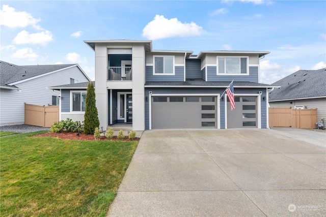 view of front of home with a balcony, a garage, and a front yard