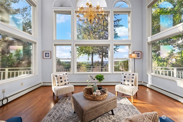 sunroom with a baseboard heating unit and a chandelier