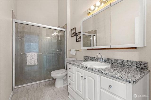 bathroom with a shower with shower door, toilet, and vanity