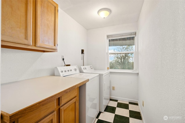 laundry room featuring washer and dryer and cabinets